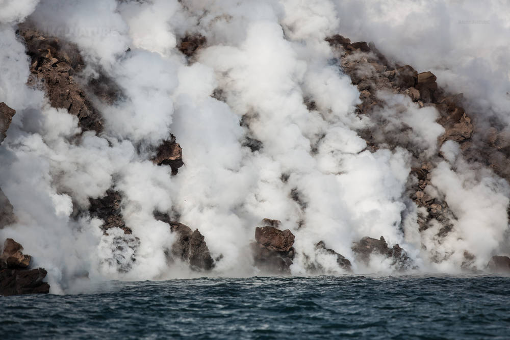 Остров Чирпой, белый дым вулканической активности.